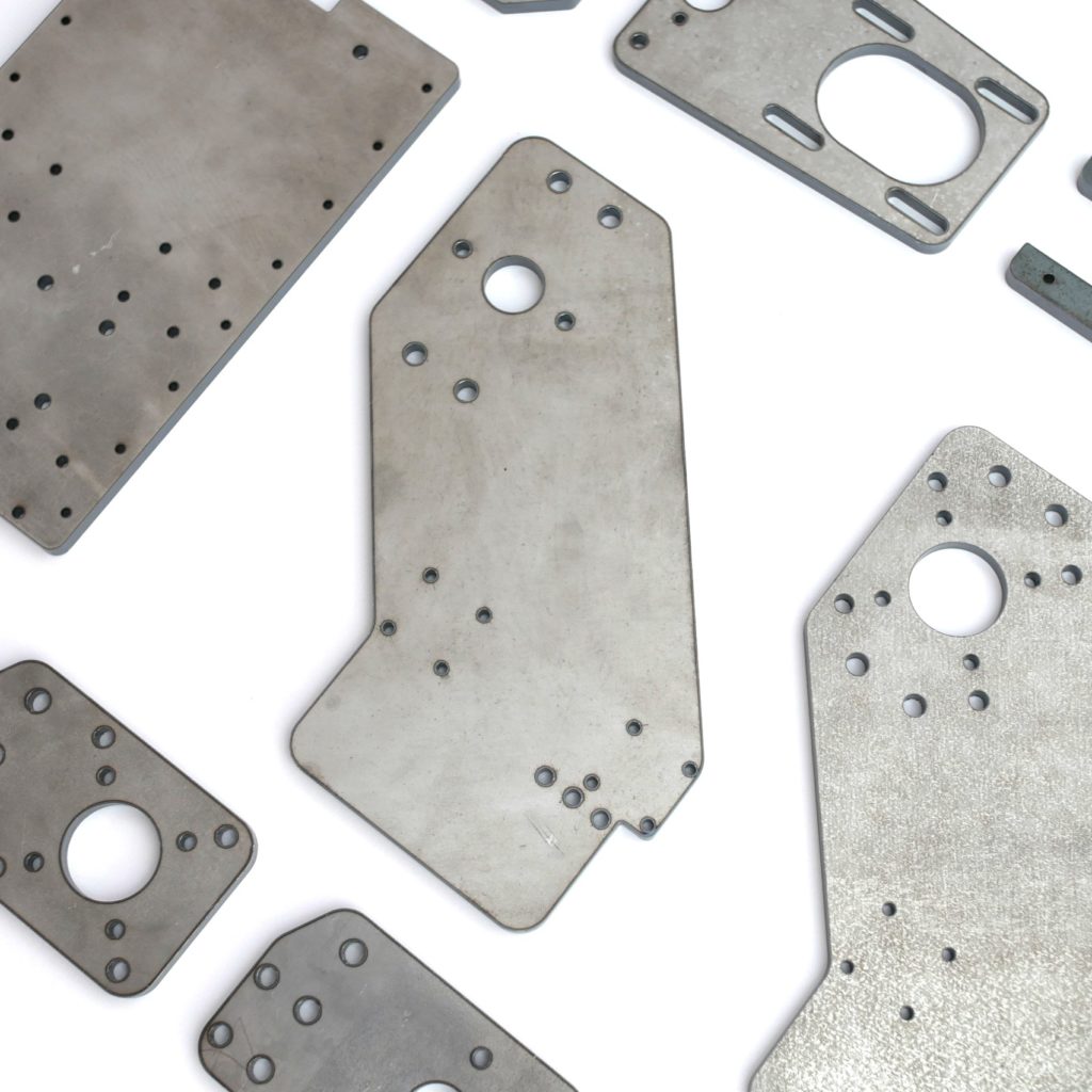 Detailed shot of laser-cut 6mm bare steel gantry and motor plates for a DIY IndyMill CNC build.